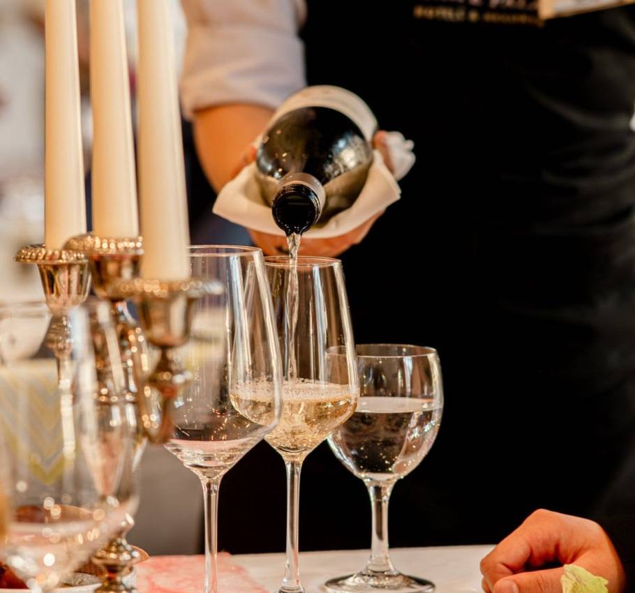 Weißwein wird am Valentinstag von unserem Service Personal in den Arkona Strandresidenzen in ein Weißweinglas geschenkt.