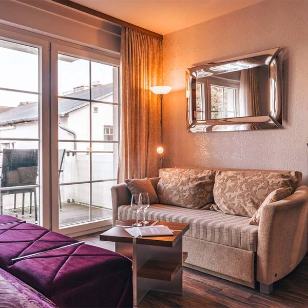 Wohnbereich mit Sofa, Couchtisch und Blick auf den Balkon im Studio der Arkona Strandresidenzen