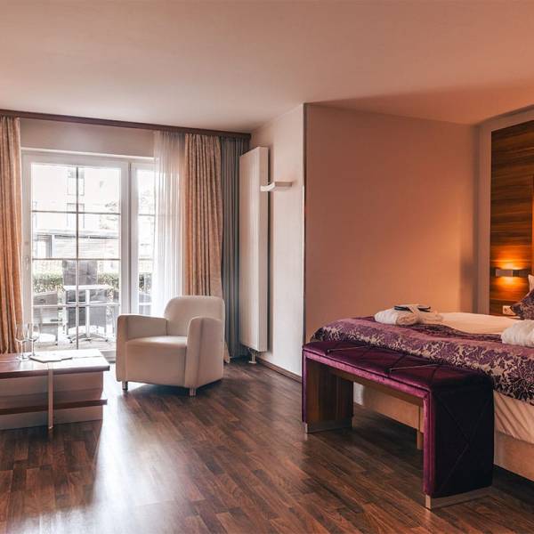 Überblick über das Superior Studio im Arkona Strandresidenzen Binz mit Doppelbett, Sofa und Balkonzugang