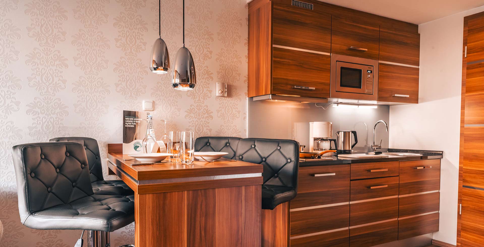 Moderne Küchenzeile mit Esstisch im Apartment der Arkona Strandresidenzen auf Rügen – ideal für Selbstversorger