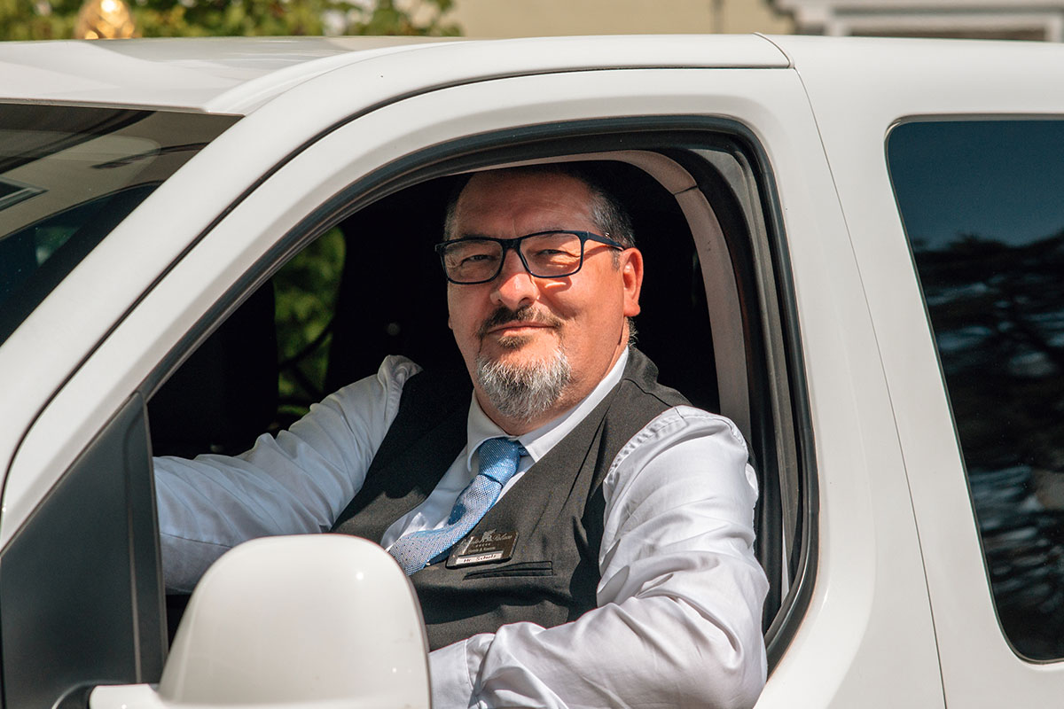 Ein Mitarbeiter der Arkona Strandresidenzen parkt ein Auto für Gäste am Hotel in Binz